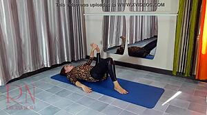 En gymnastikmodel i strømpebukser og yogabukser viser sin fleksibilitet