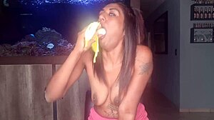 En barmfagre indisk kvinde glæder sig ved at kærtegne sine bryster og udføre oralsex på en banan i en solovideo